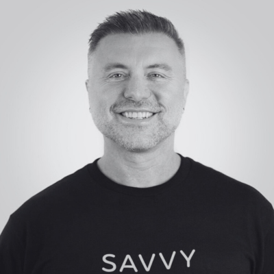 Smiling person wearing a "SAVVY" shirt against a plain background.